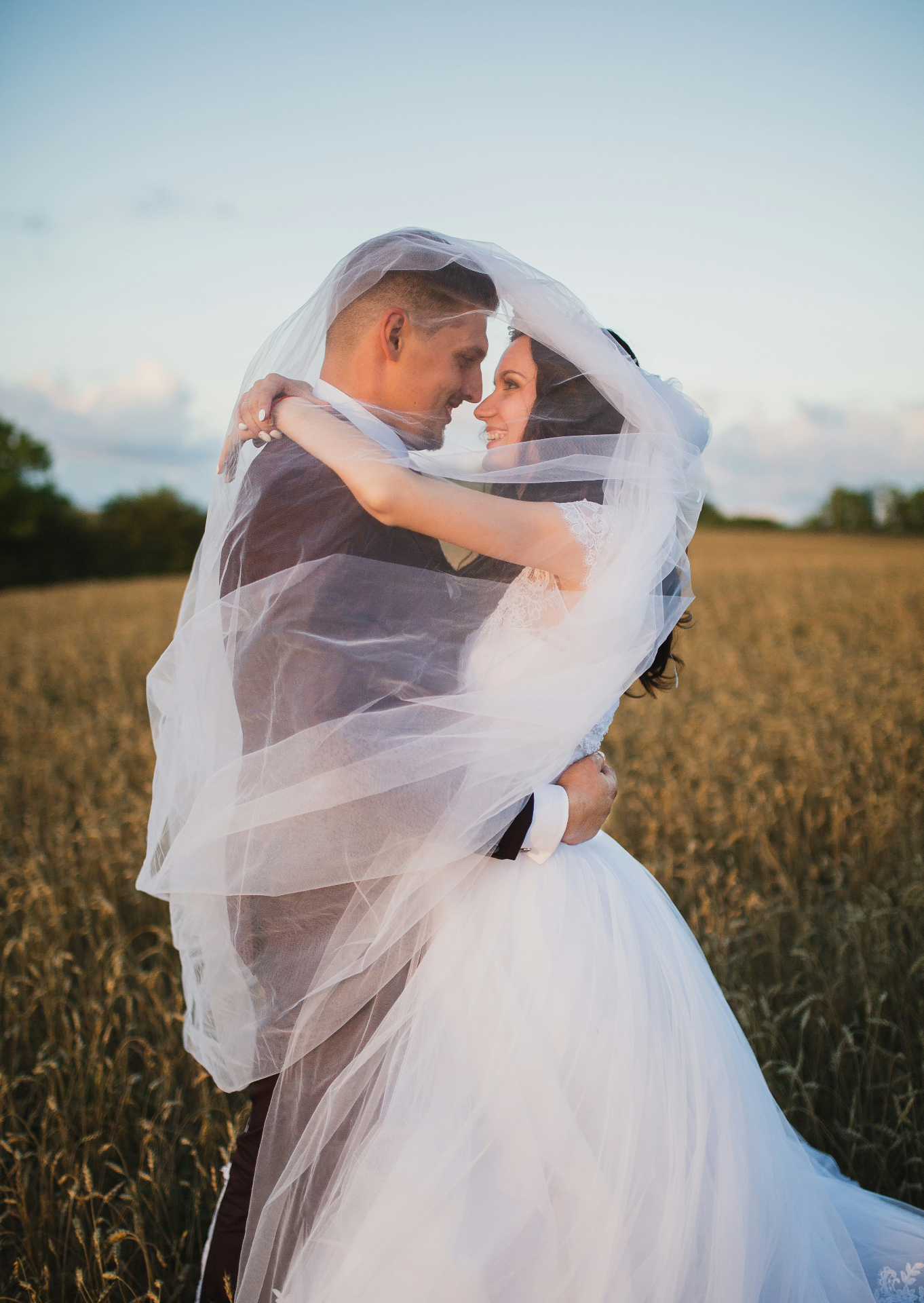 Bride and groom under a sweeping veil